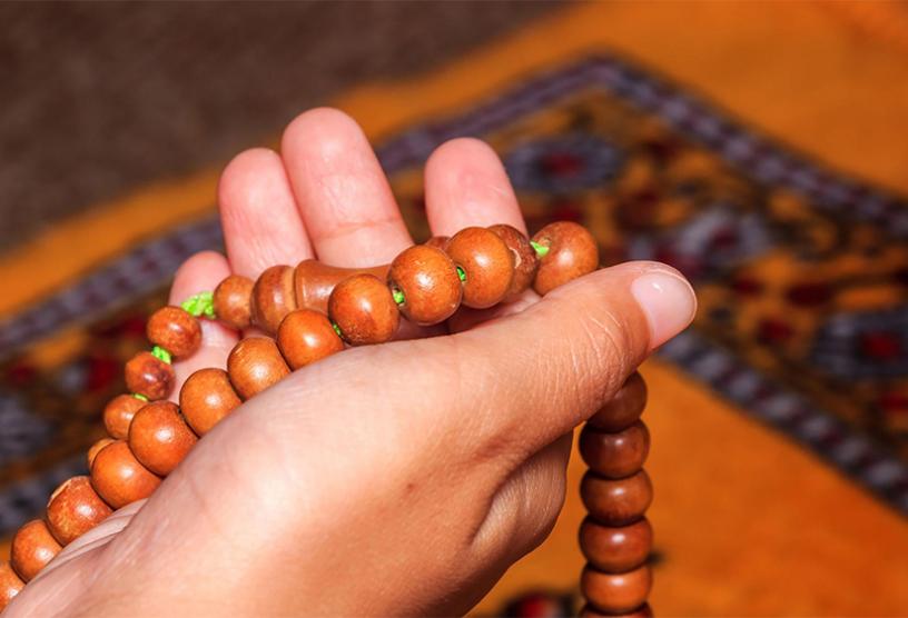 Hand holding religious beads